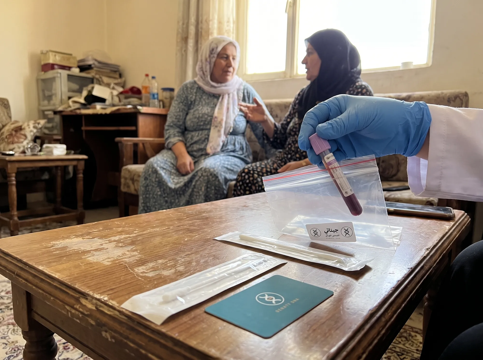 Iraqi parents with a Geneti sample kit on the table